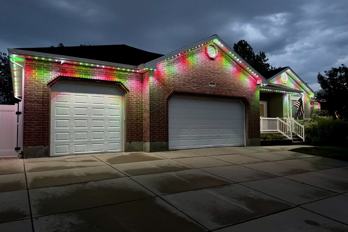 Home roofline lit with classic red and green Christmas lights