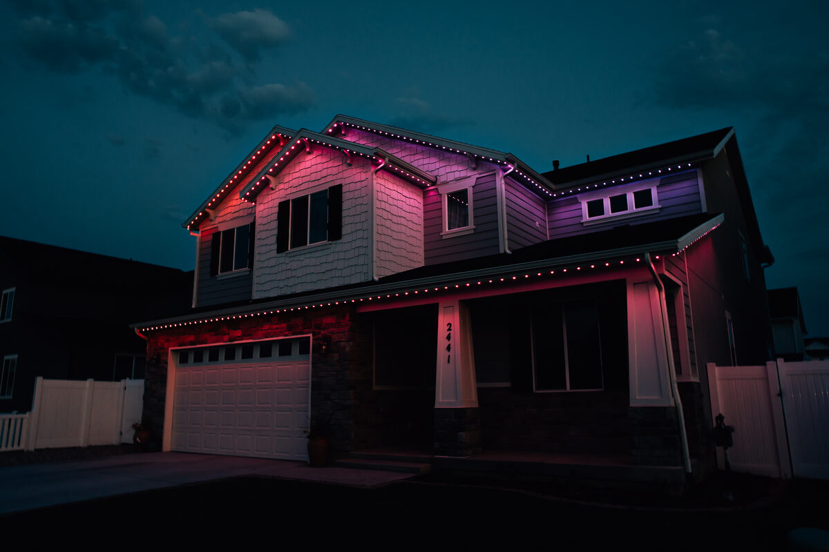 Home roofline lit with team colors in purple and pink for game day