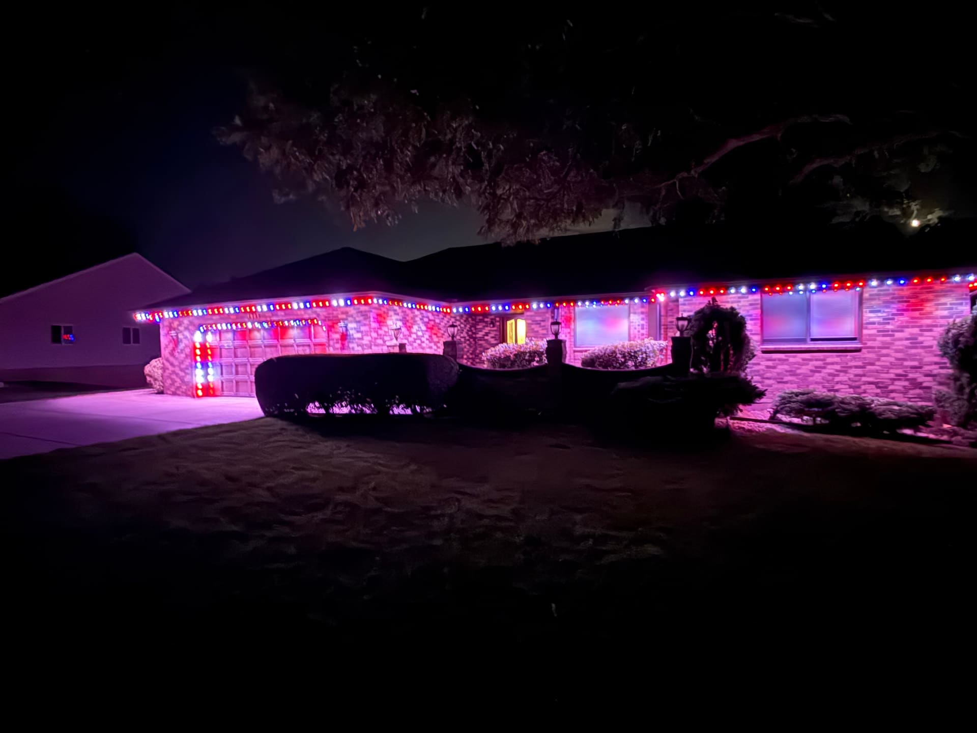 Brick rancher with a full red, white, and blue patriotic lighting display