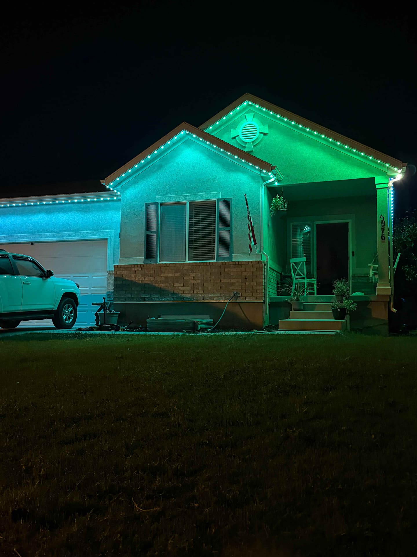 Teal stucco home with permanent lighting