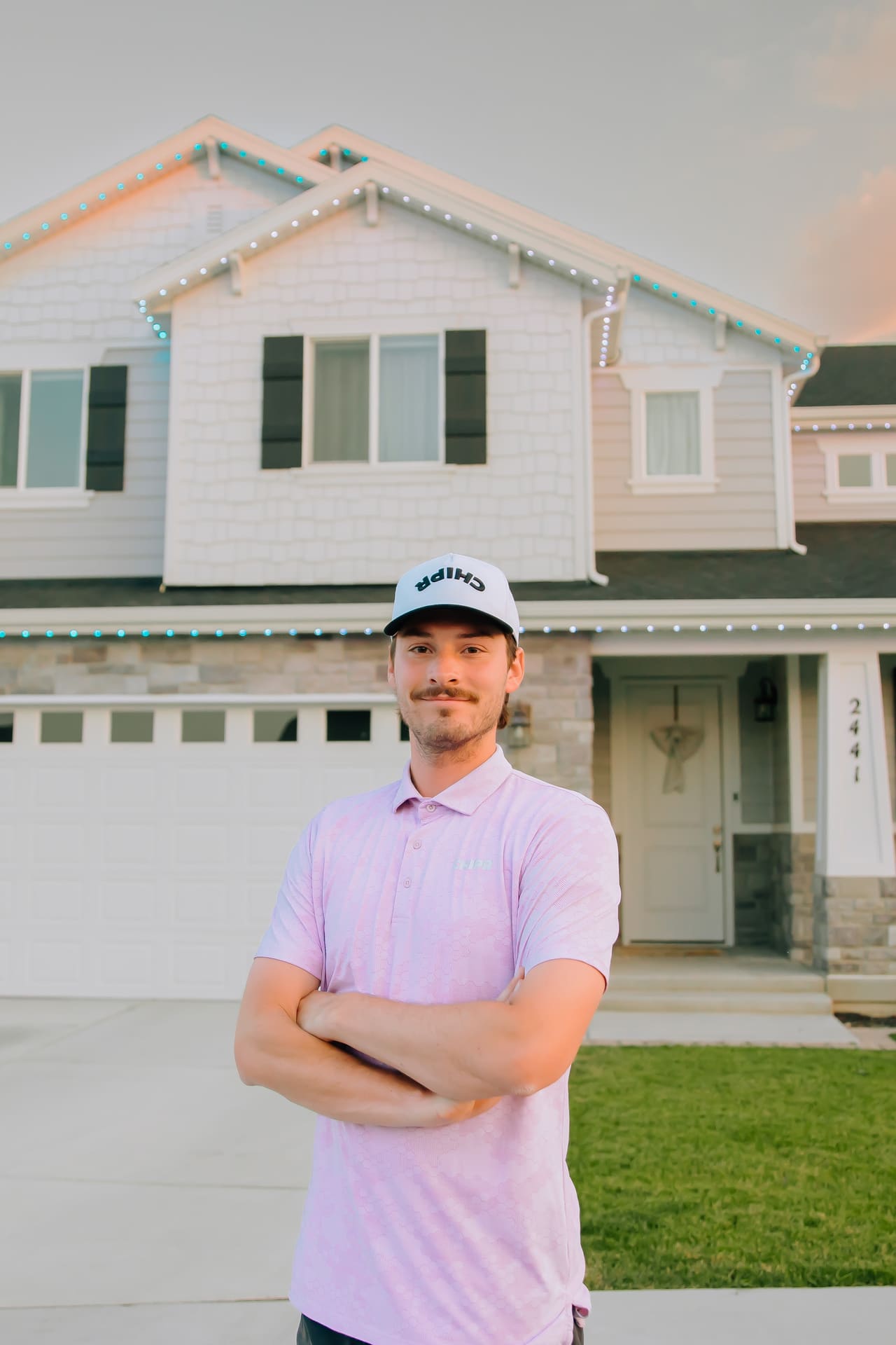 Chipr Lux team member standing in front of a home with permanent lighting